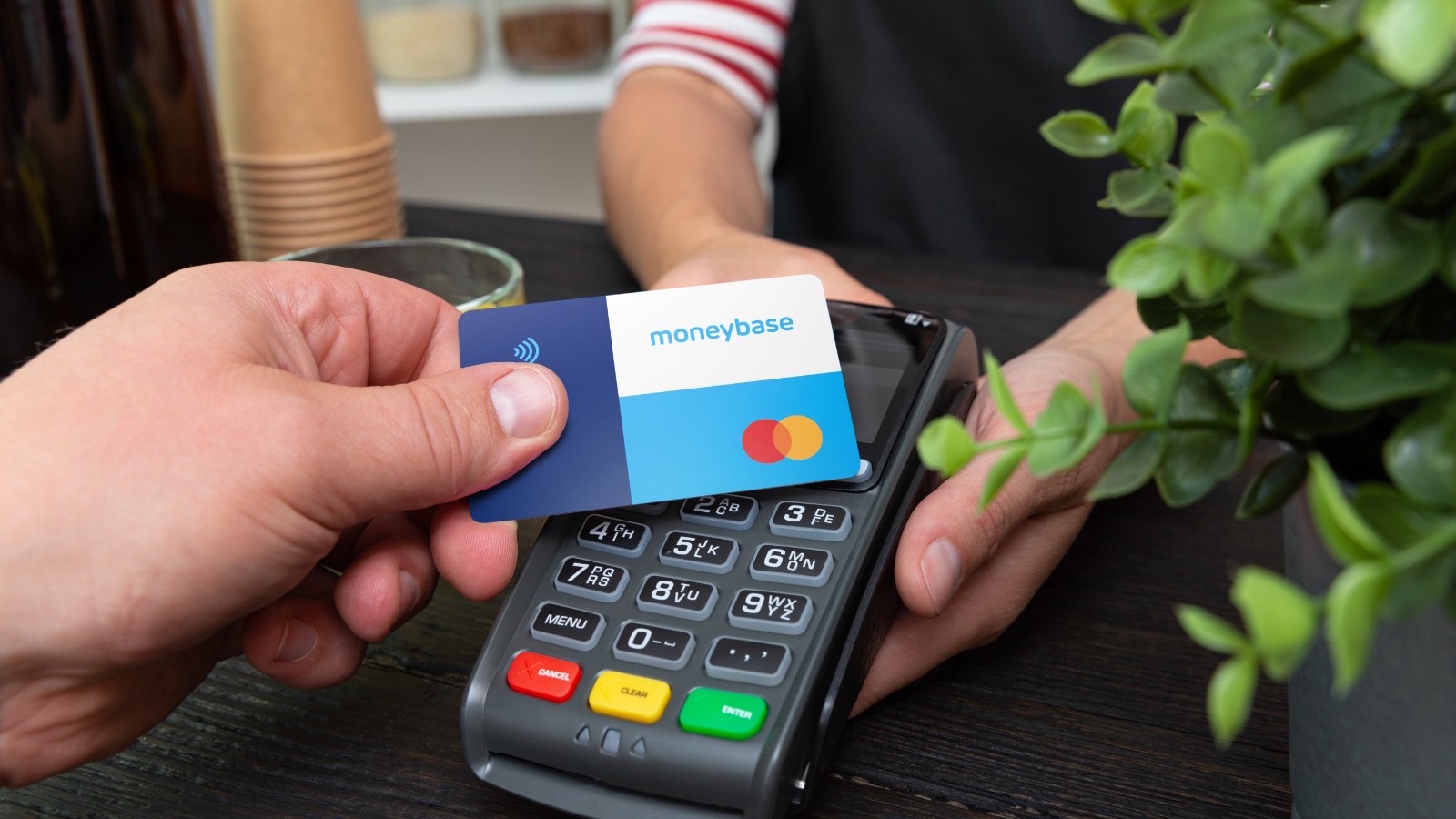 Contactless payment with a Moneybase Mastercard at a cafe counter